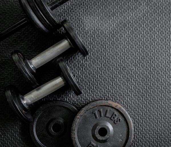 Dumbbell, weights, and other fitness equipment on mat